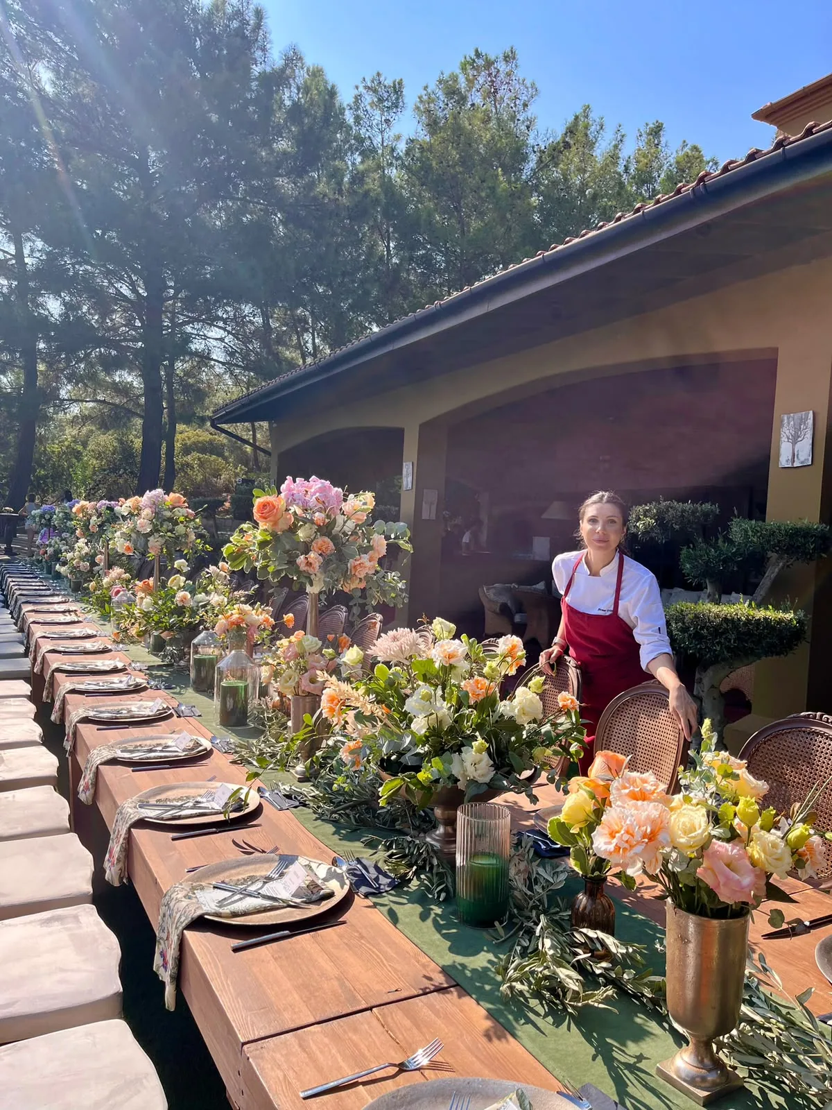 A long table dressed with flowers in a garden